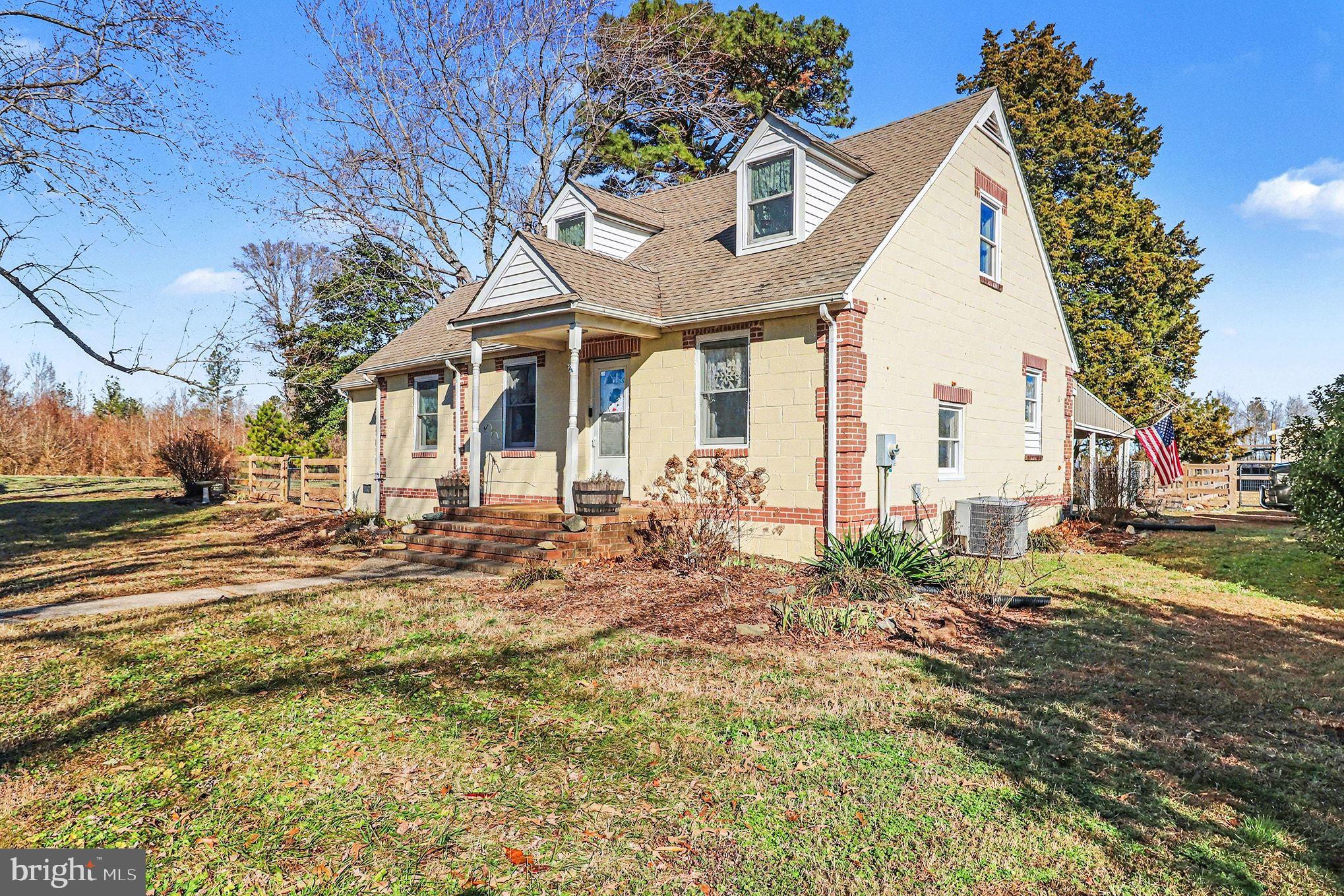 2033 Courthouse Road Heathsville, VA 22473 - Photo 2 of 50 a view of a white house with a yard and lawn chairs under an umbrella