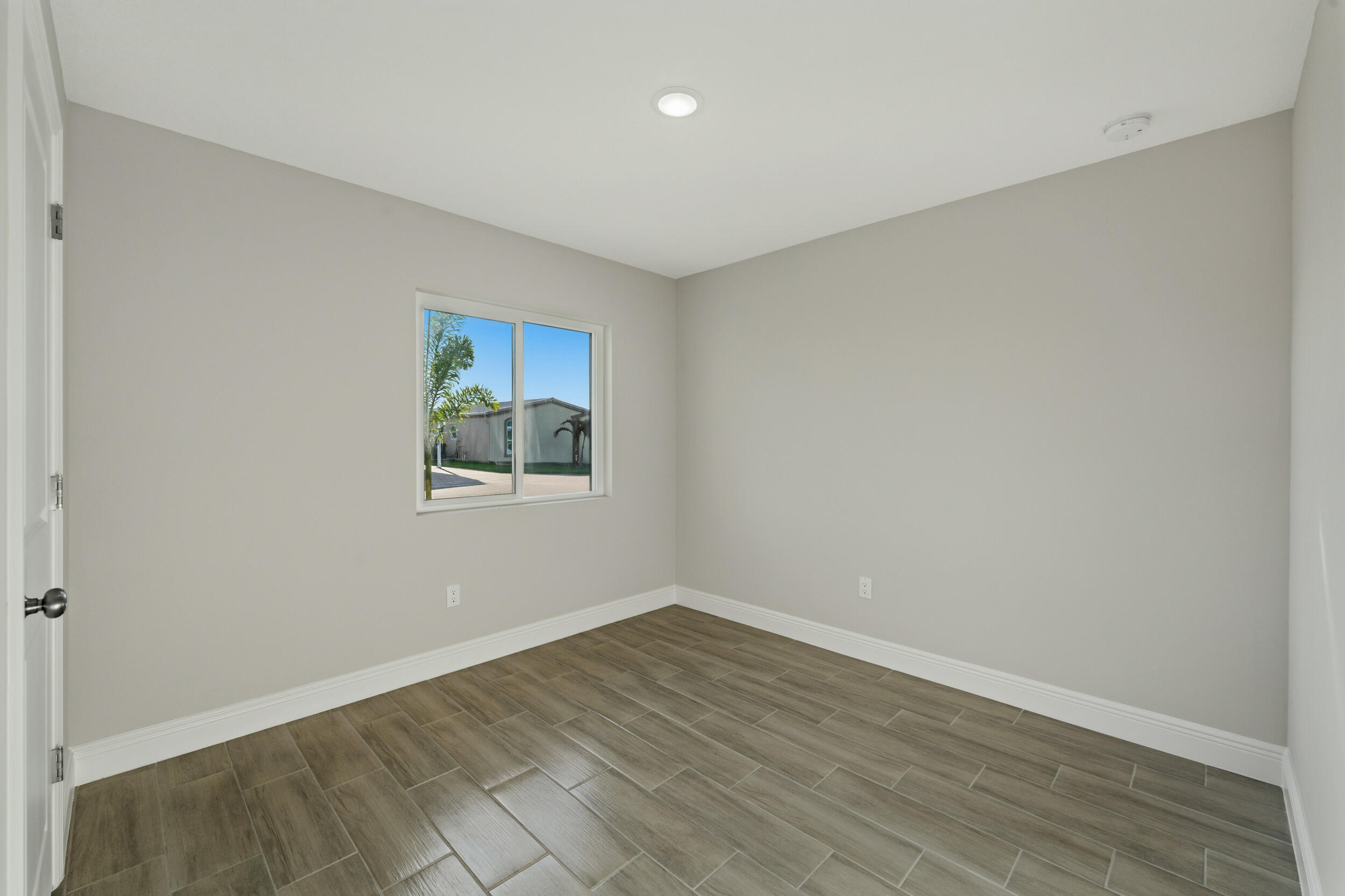 4335 Southwest 15th Way Okeechobee, FL 34974 - Photo 21 of 33 wooden floor in an empty room with a window