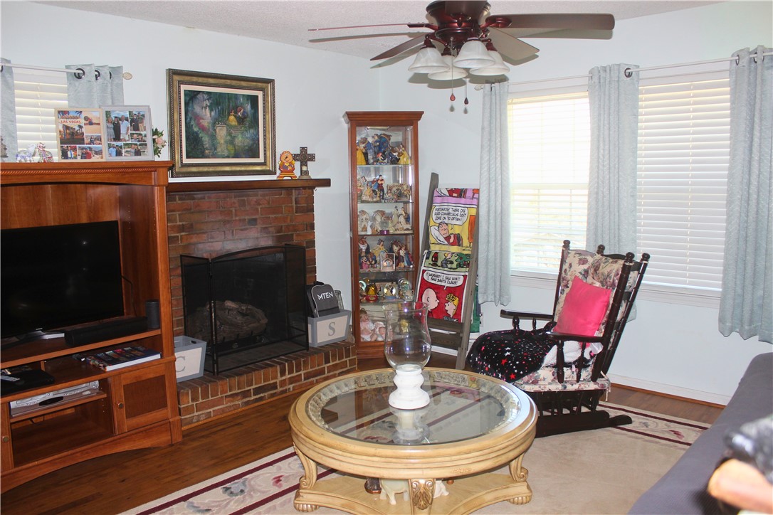 104 Laurel Lane Seneca, SC 29678 - Photo 6 of 34 This inviting living room features a classic brick fireplace and rich hardwood flooring.