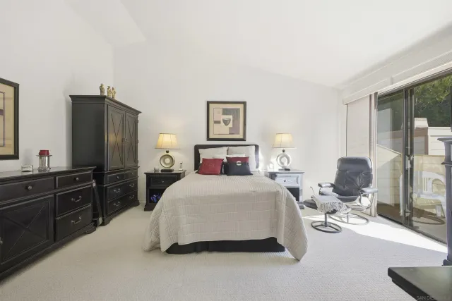 a bedroom with a bed and dresser with mirror