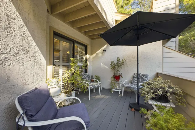 a patio with wooden floor table and chairs