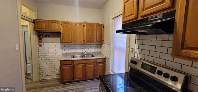 a kitchen with stainless steel appliances wooden cabinets and a stove top oven