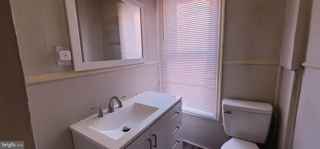 a bathroom with a sink a toilet and mirror