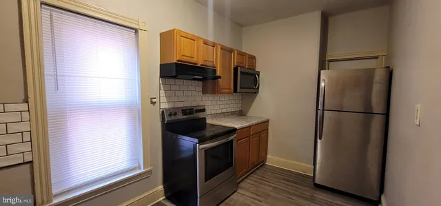 a kitchen with stainless steel appliances granite countertop a refrigerator and a stove