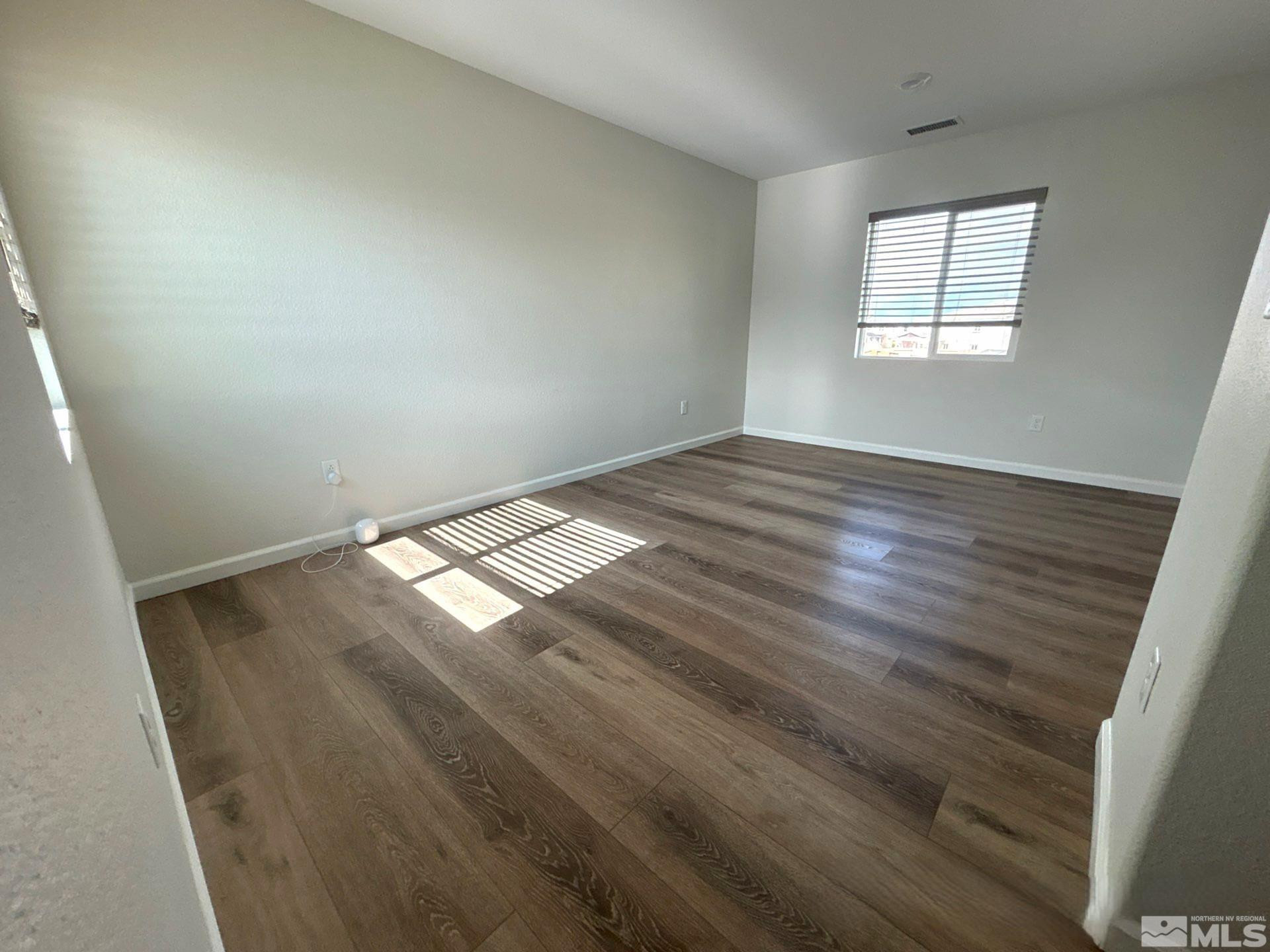 8908 Quail Falls Drive Reno, NV 89506 - Photo 14 of 20 an empty room with wooden floor and windows