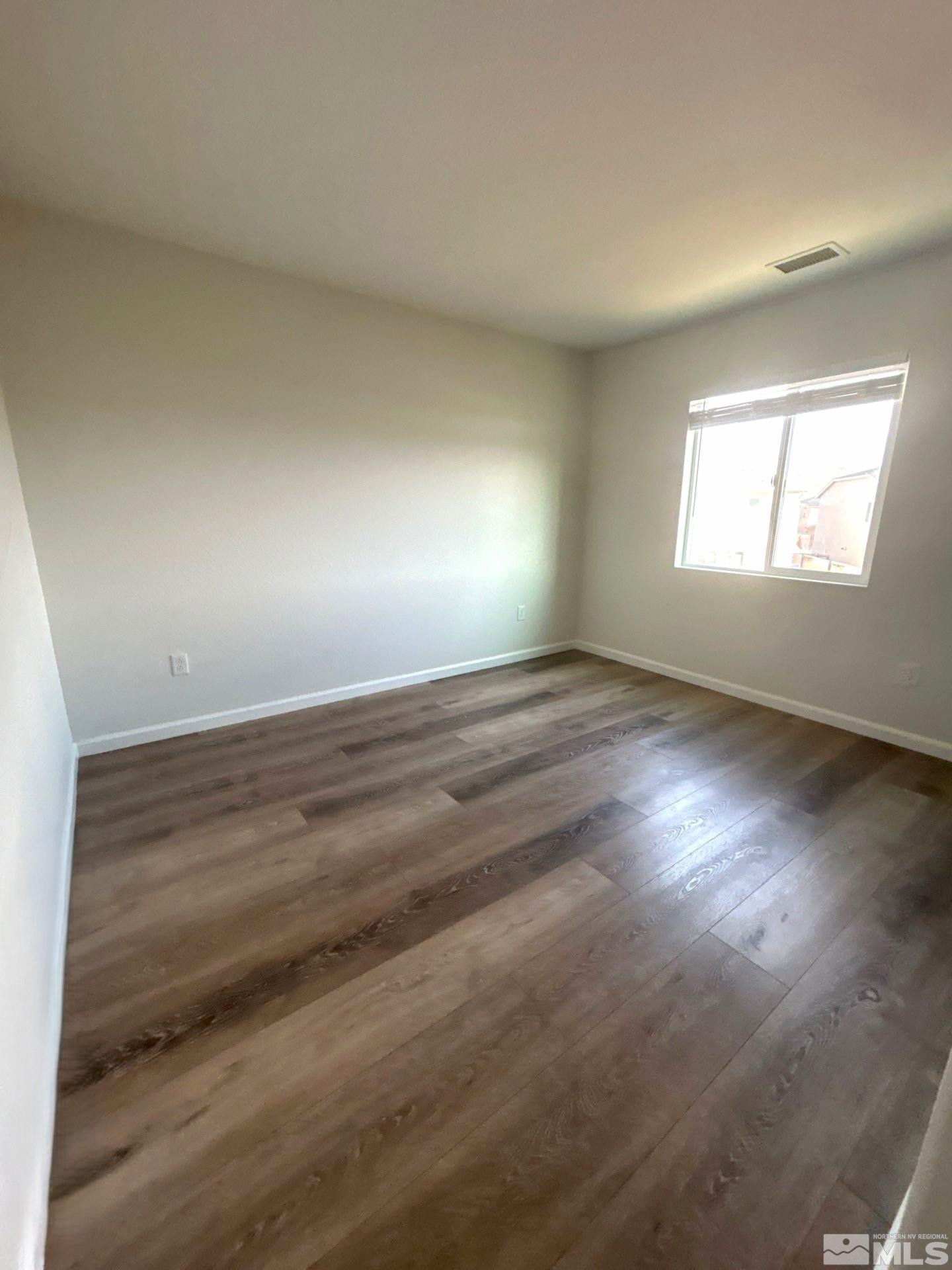 8908 Quail Falls Drive Reno, NV 89506 - Photo 16 of 20 an empty room with wooden floor and windows