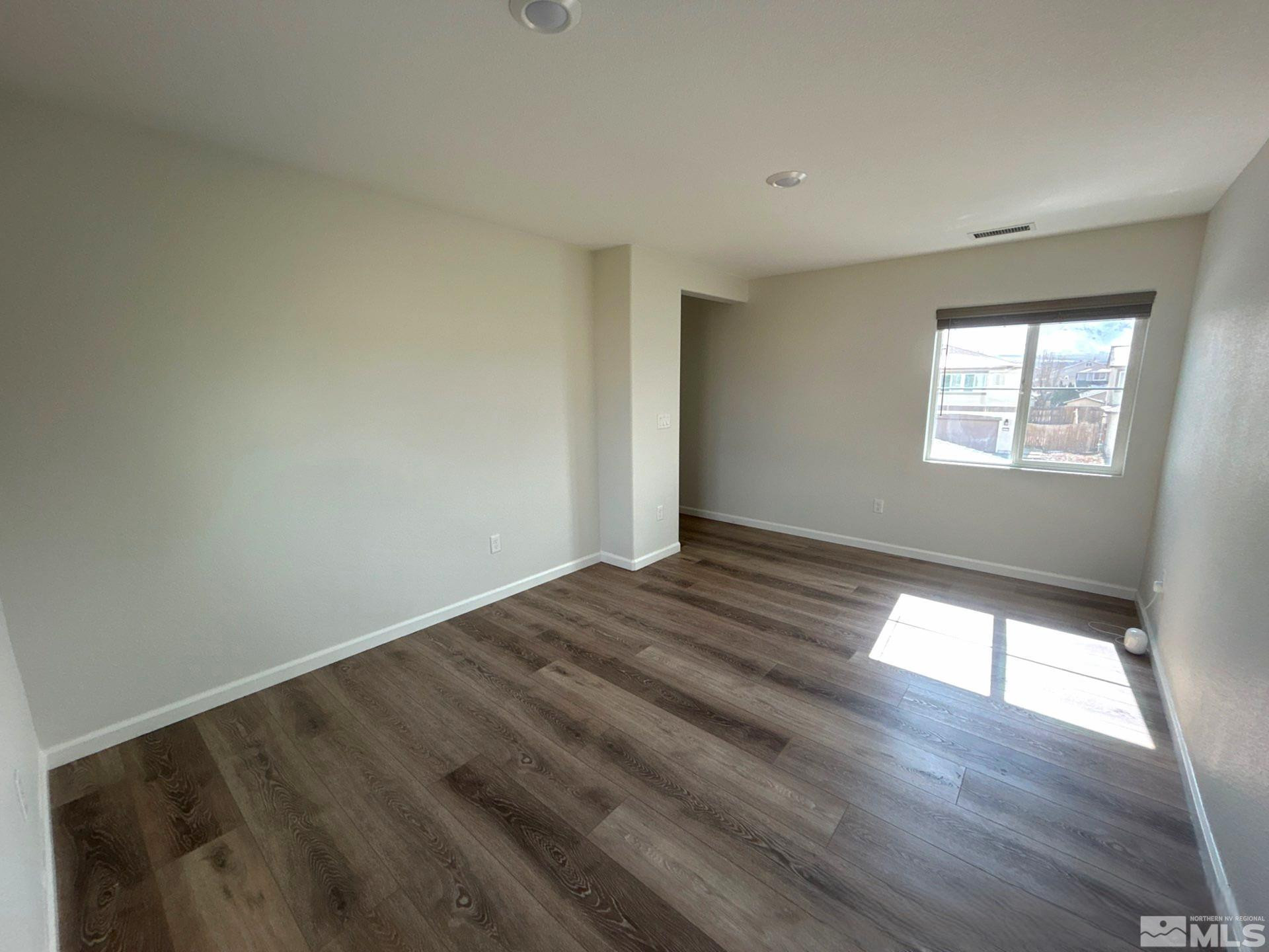 8908 Quail Falls Drive Reno, NV 89506 - Photo 18 of 20 a view of empty room with wooden floor and fan