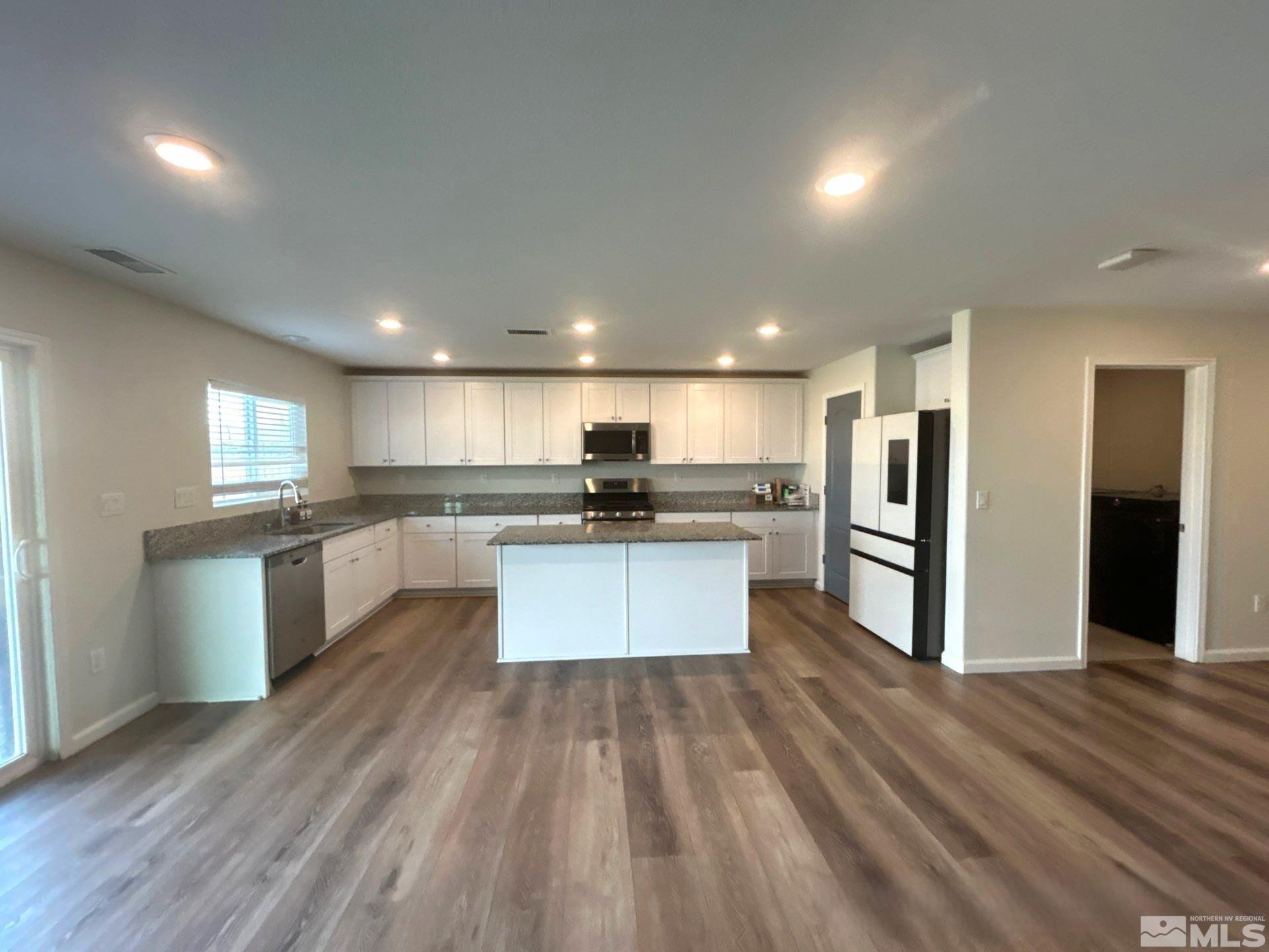 8908 Quail Falls Drive Reno, NV 89506 - Photo 7 of 20 a large kitchen with stainless steel appliances kitchen island a large counter top and a refrigerator