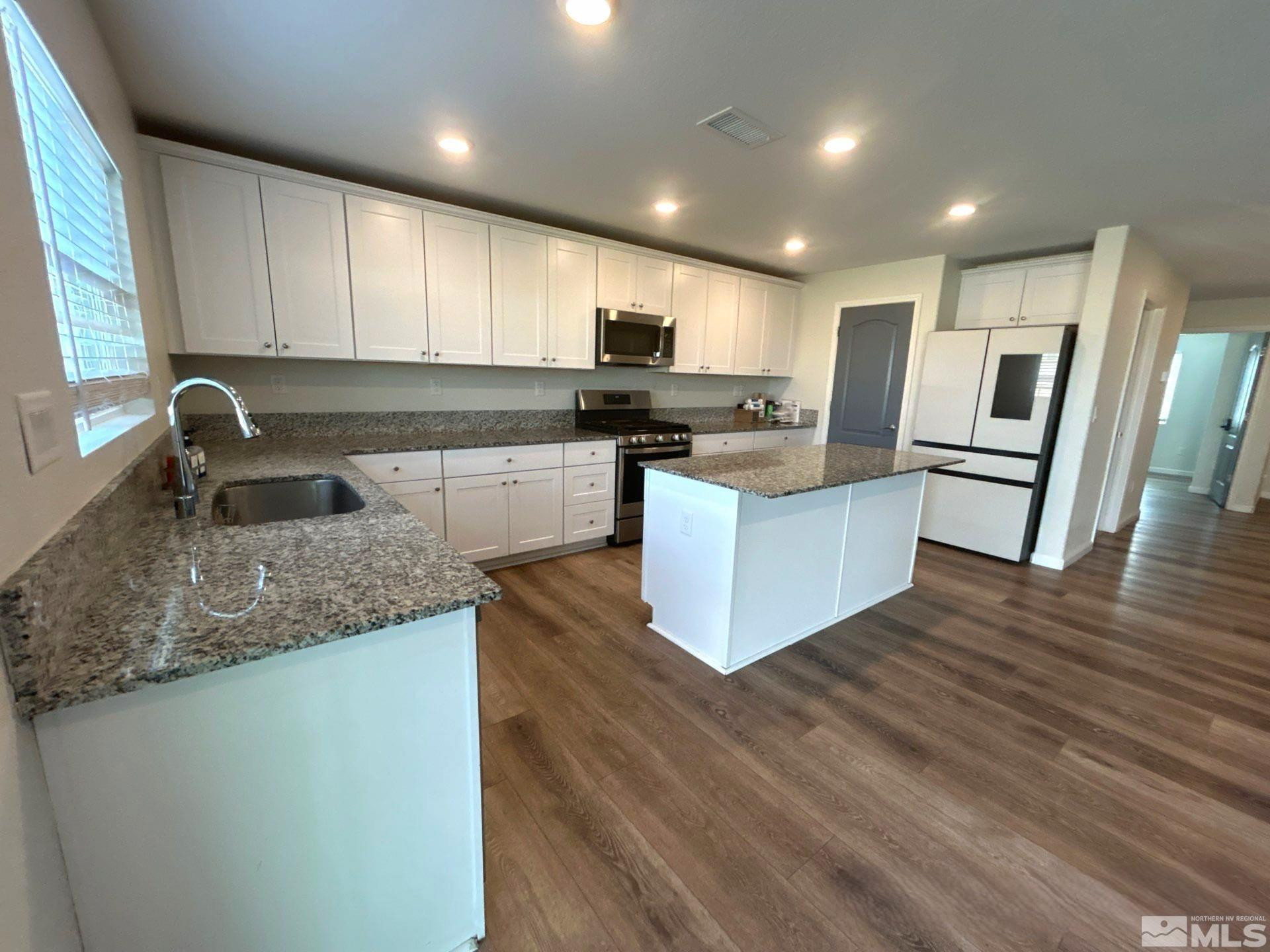 8908 Quail Falls Drive Reno, NV 89506 - Photo 8 of 20 a kitchen with stainless steel appliances granite countertop a sink stove and refrigerator