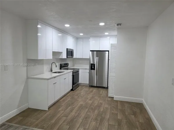 a kitchen with stainless steel appliances granite countertop a sink a stove a microwave and cabinets