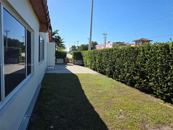 a view of a house with a yard and potted plants