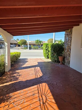 a view of a white house with a big yard and potted plants