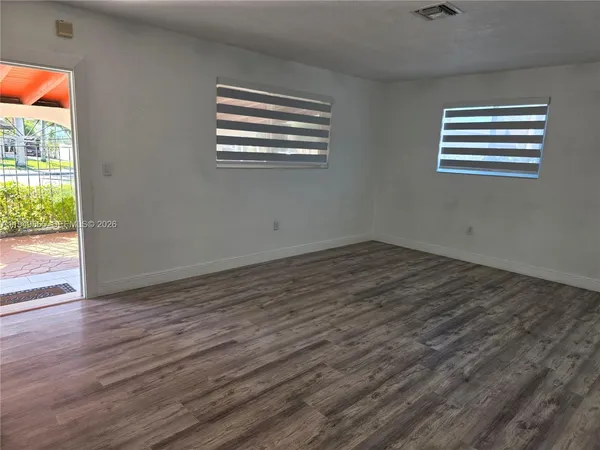 a view of empty room with wooden floor