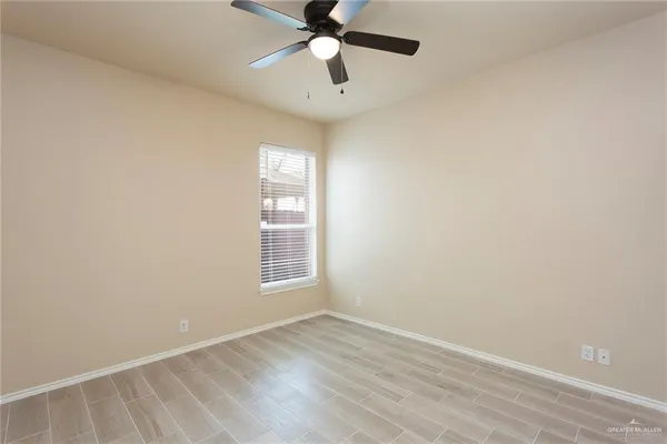 an empty room with windows and fan