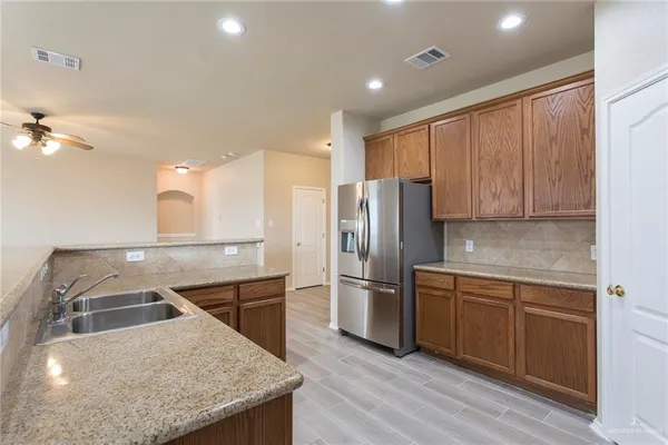 a kitchen with stainless steel appliances granite countertop a refrigerator a sink and a stove