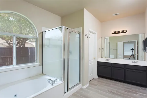 a bathroom with a tub sink and mirror