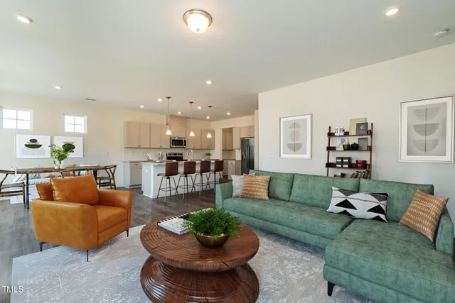 a living room with furniture kitchen and a table