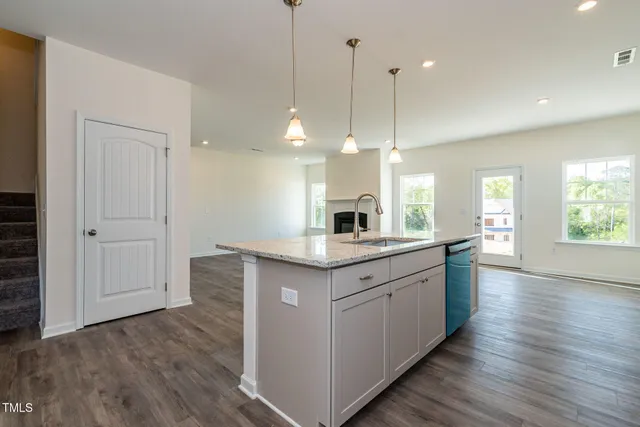 a kitchen with granite countertop a sink and a wooden floor