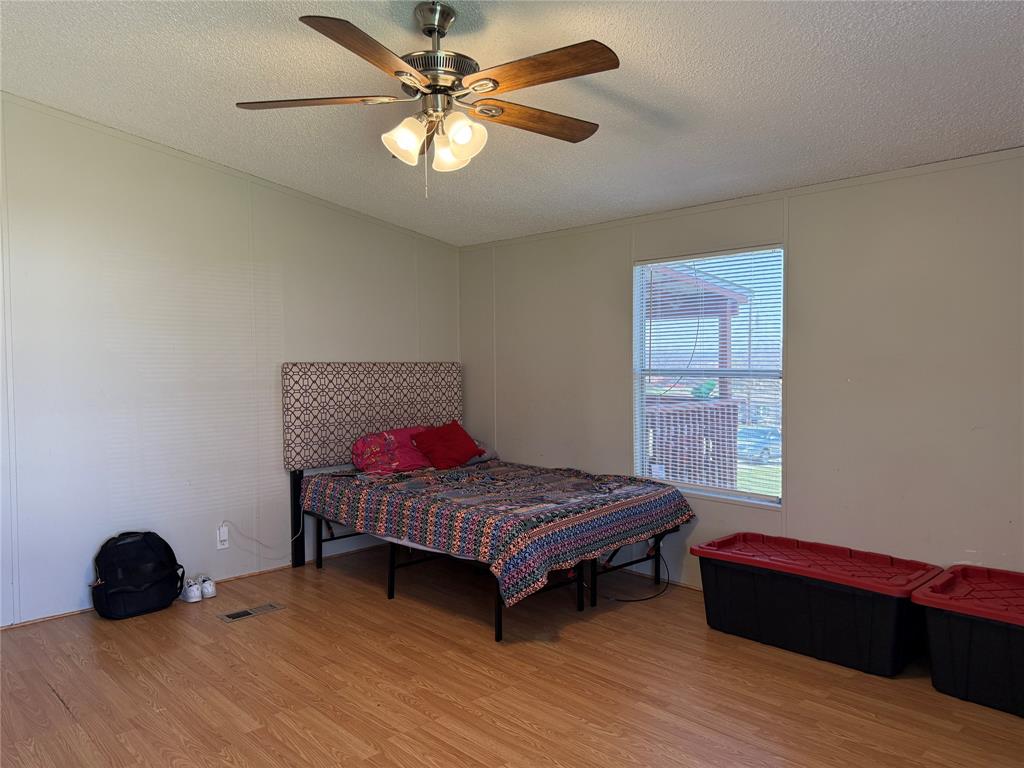 167 Blue Sky Lane Springtown, TX 76082 - Photo 12 of 34 a bedroom with a bed a window and a chandelier