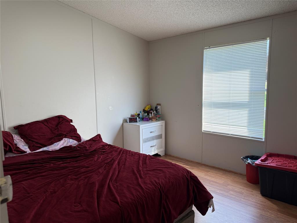 167 Blue Sky Lane Springtown, TX 76082 - Photo 17 of 34 a bedroom with a bed and wooden floor