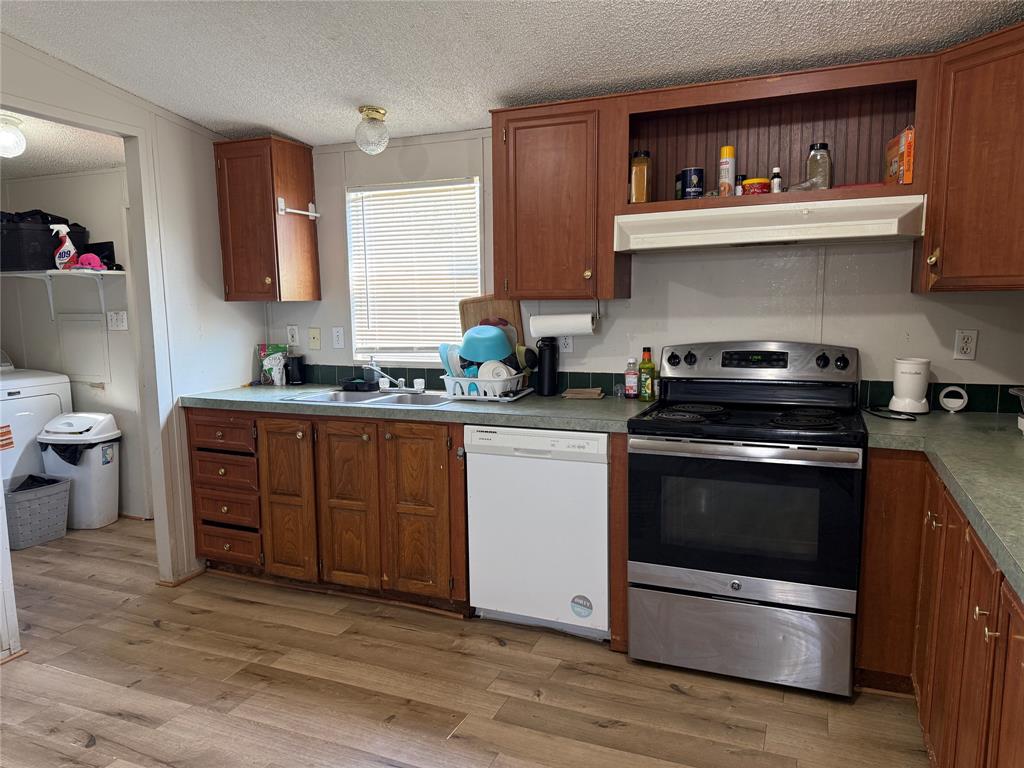 167 Blue Sky Lane Springtown, TX 76082 - Photo 19 of 34 a kitchen with stainless steel appliances a stove a sink and wooden floors