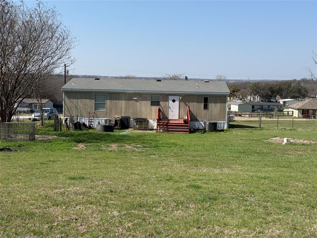 167 Blue Sky Lane Springtown, TX 76082 - Photo 27 of 34 a front view of a house with a garden and trees