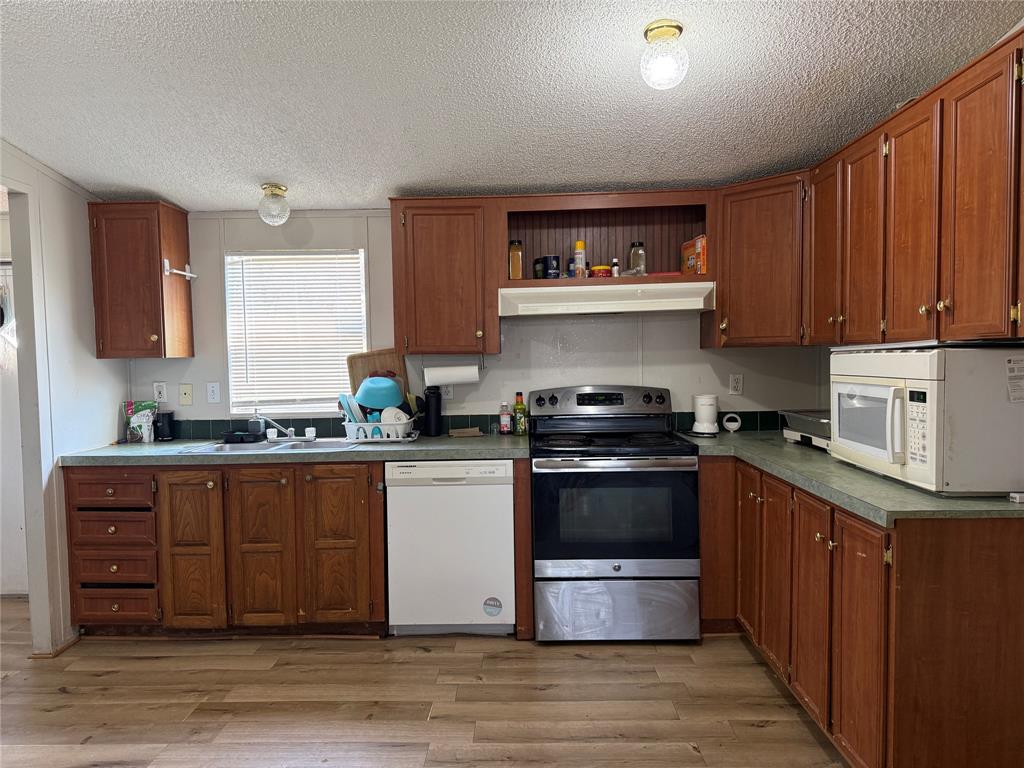 167 Blue Sky Lane Springtown, TX 76082 - Photo 5 of 34 a kitchen with stainless steel appliances granite countertop a stove and a sink