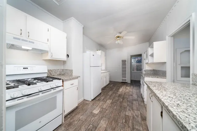 a kitchen with white cabinets and appliances
