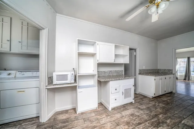 a kitchen with white cabinets and white appliances