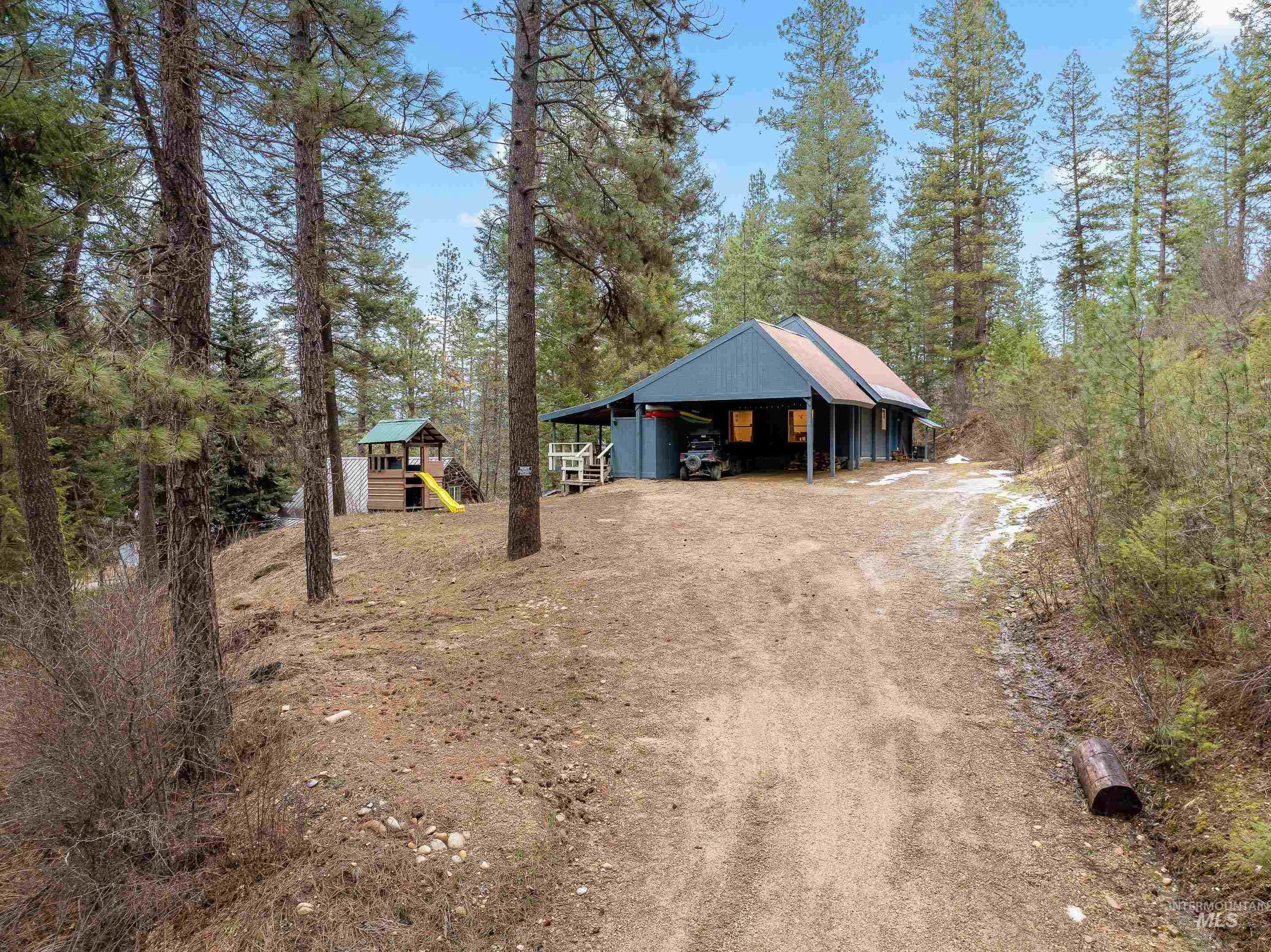 32 Sky Ridge Drive Garden Valley, ID 83622 - Photo 37 of 37 View of front of home featuring an outbuilding, a carport, dirt driveway, and a playground