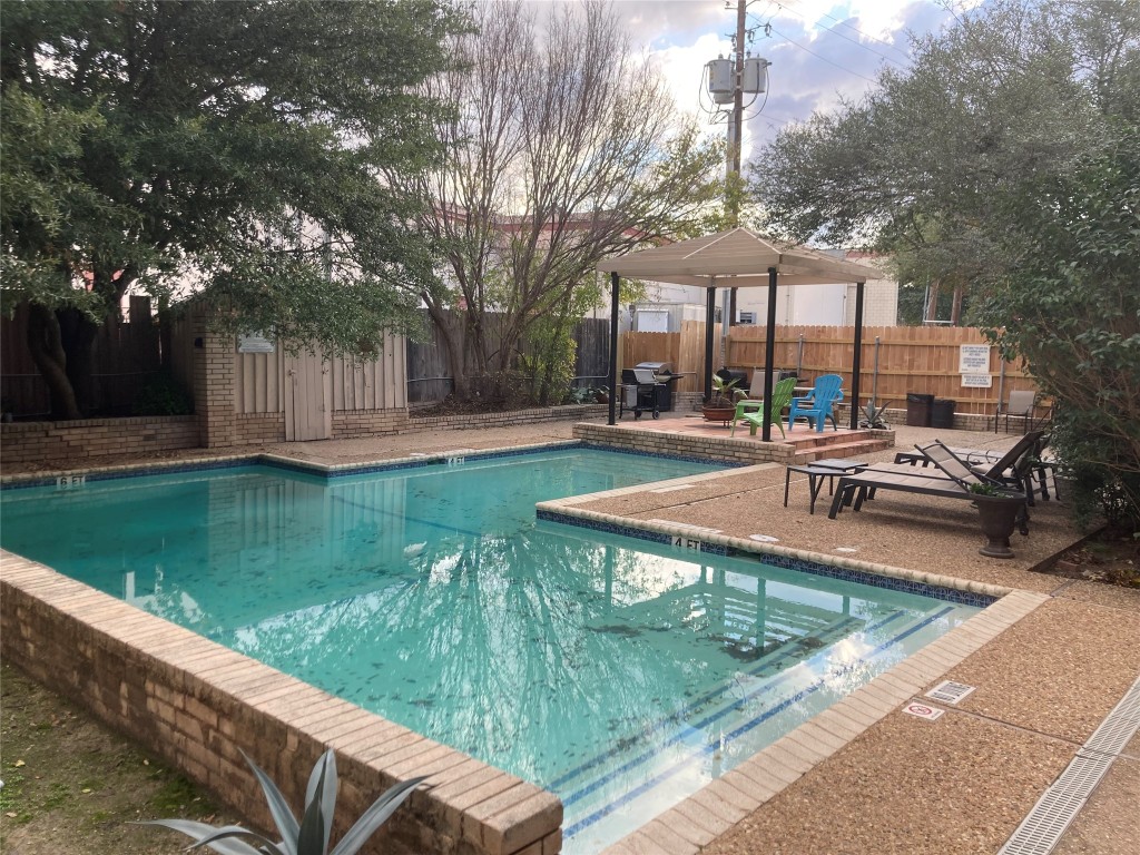 a view of a swimming pool with a patio and a yard