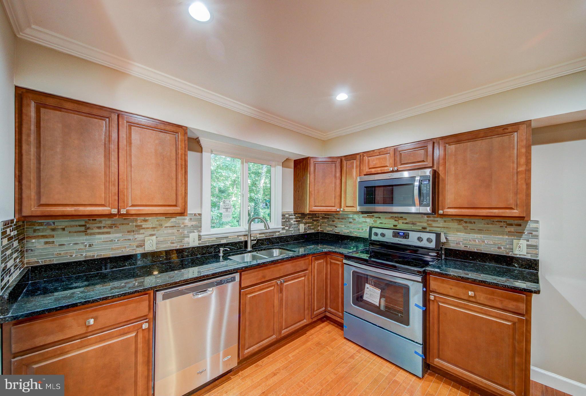2459 Pyrenees Court Reston, VA 20191 - Photo 4 of 28 a kitchen with stainless steel appliances granite countertop a sink a stove cabinets and a counter top space