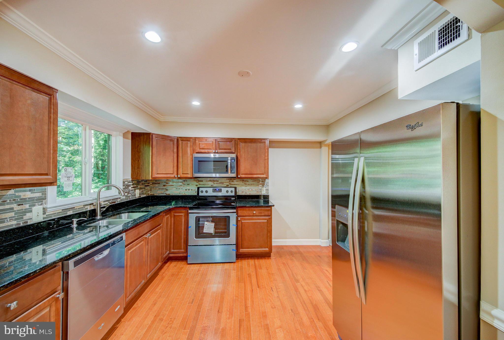 2459 Pyrenees Court Reston, VA 20191 - Photo 5 of 28 a large kitchen with stainless steel appliances granite countertop a refrigerator a sink a stove and wooden cabinets