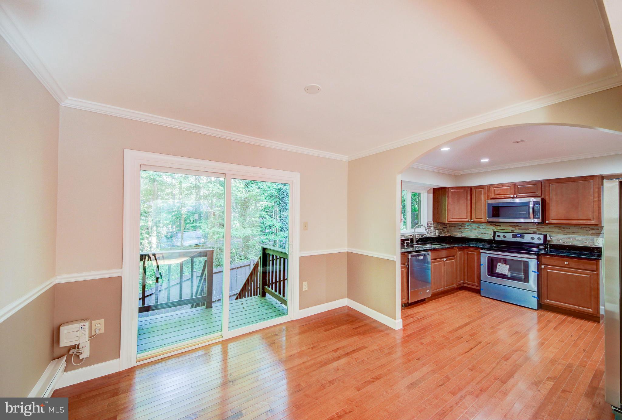 2459 Pyrenees Court Reston, VA 20191 - Photo 7 of 28 a large kitchen with kitchen island a large counter top space a sink a stove and a large window