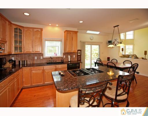98 Bennett Road Old Bridge, NJ 07747 - Photo 2 of 10 a kitchen with stainless steel appliances granite countertop a stove a sink a microwave a dining table and chairs