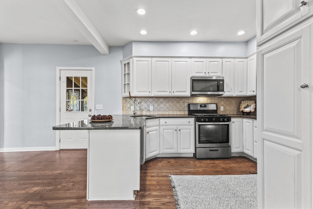 1142 Washington Street Whitman, MA 02382 - Photo 12 of 32 a kitchen with kitchen island a stove a sink and a microwave