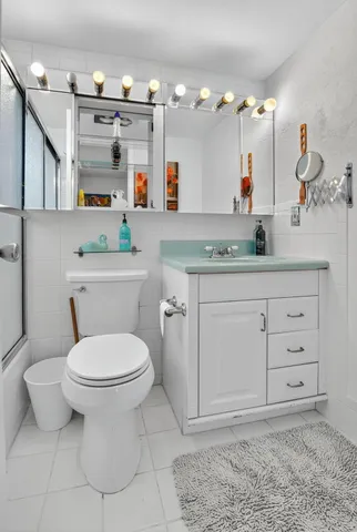 a bathroom with a sink a toilet and mirror
