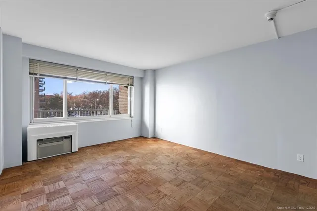 a view of empty room with a window and a kitchen