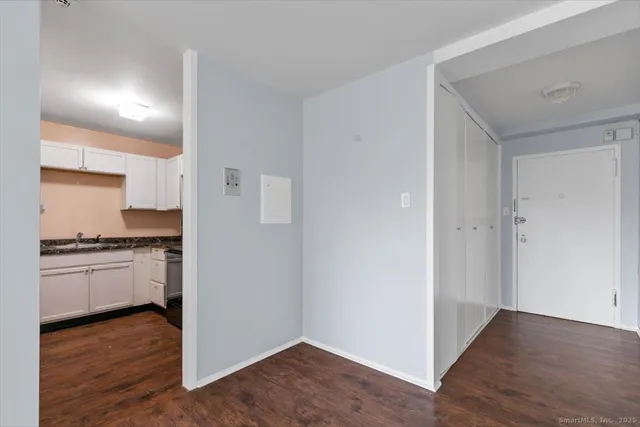 a kitchen with granite countertop white cabinets and stainless steel appliances