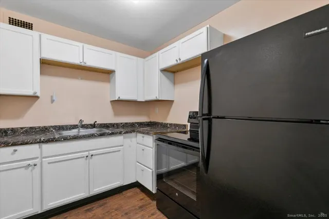 a kitchen with granite countertop cabinets stainless steel appliances and a counter space