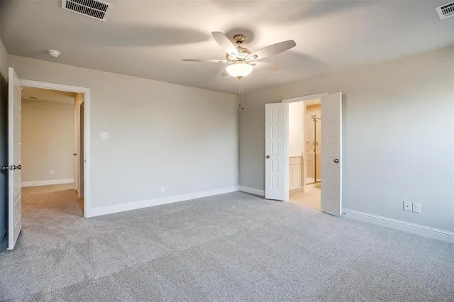 a view of an empty room with a chandelier fan