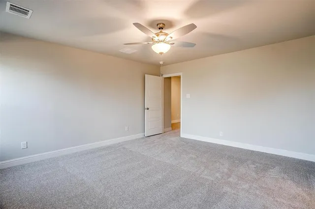 a view of an empty room with a ceiling fan and a window
