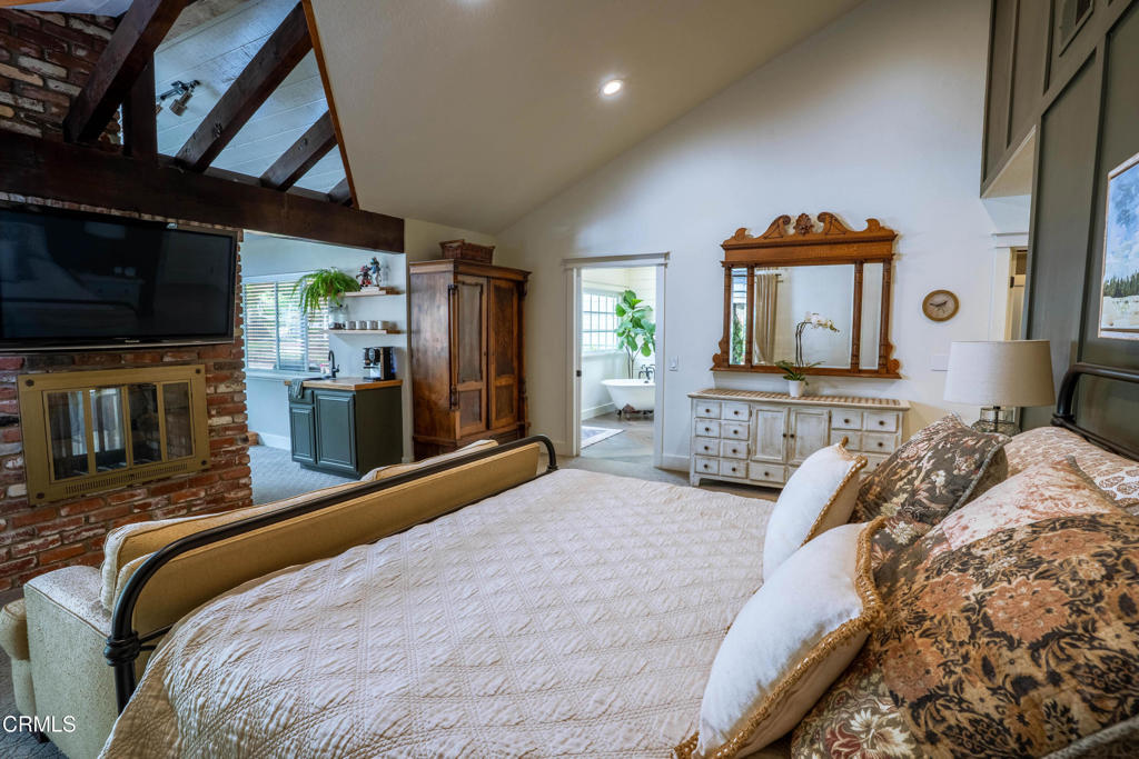 12075 East Pradera Road Camarillo, CA 93012 - Photo 25 of 54 a bedroom with a bed a fireplace and a flat tv screen