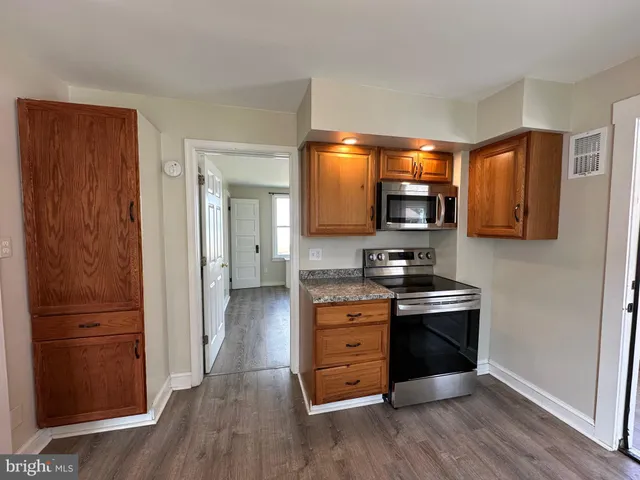 a kitchen with stainless steel appliances granite countertop a refrigerator and a stove top oven