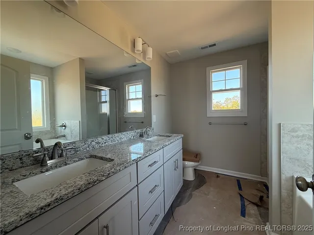 a bathroom with a granite countertop sink mirror and double