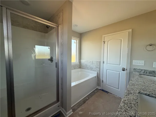 a bathroom with a tub a sink and a large mirror