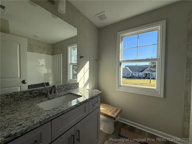 a bathroom with a granite countertop sink and a mirror