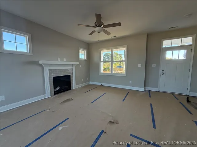 an empty room with windows and fireplace
