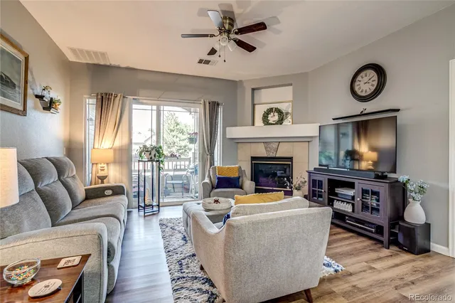 a living room with furniture a flat screen tv and a fireplace