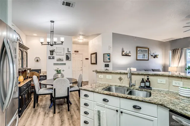 a kitchen with granite countertop a sink stainless steel appliances and dining table